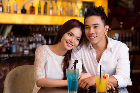 Young lovers spending an evening in a bar or a cafe over cocktailsの写真素材