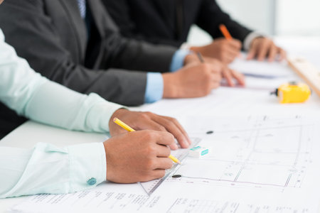 Close-up image of architects being occupied with paperwork