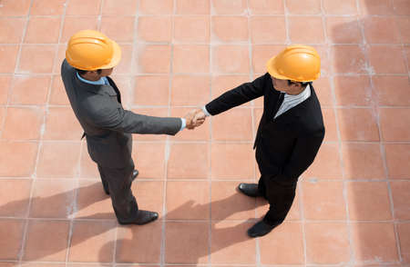 The above-view of businessmen shaking hands on the construction siteの写真素材