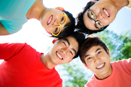 Cool classmates standing head to head and smiling, concept of unity and team-spirit