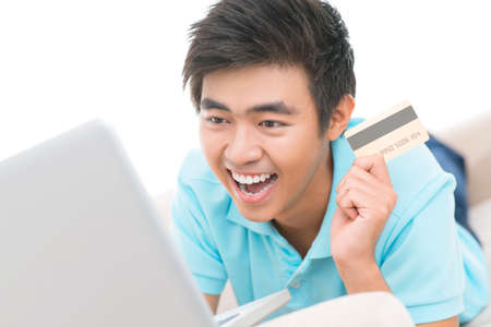Excited guy making a bargain purchase onlineの写真素材