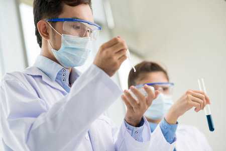 Lab workers wearing protective uniform studying samples