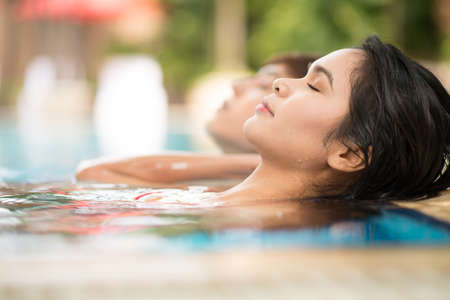 Young couple relaxing in water in a spa resortの写真素材