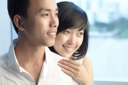 Smiling man looking at something with his girlfriend behindの写真素材