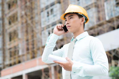 Young project manager calling by phone to clarify important detailsの写真素材