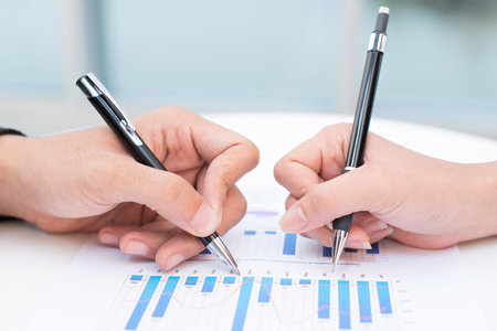 Close-up of a business documents with graphs analyzed by business people