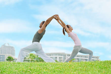 Young couple doing yoga outdoorsの写真素材