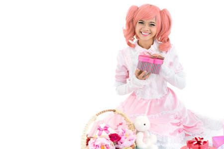 Isolated portrait of a cheerful birthday girl in pink opening presentsの写真素材