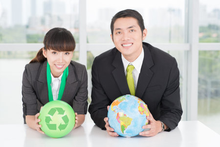Image of businesspeople with a globe and a recycled circle in handsの写真素材