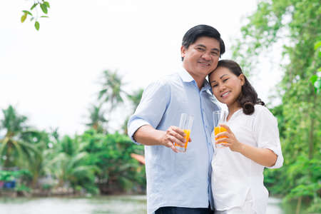 Copy-spaced portrait of a mature couple in-love standing and posing at camera outsideの写真素材