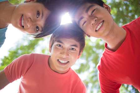 Image of happy friends standing in a circle outsideの写真素材