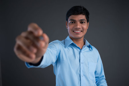 Close-up of a friendly young man in formalwear writing in penの写真素材