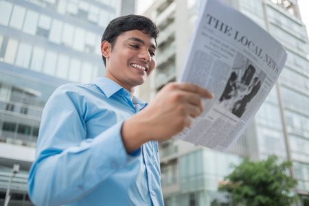 Joyful white-collar worker reading the daily newsの写真素材