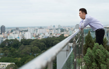 Profile view of a young businessman being in deep frustration outsideの写真素材