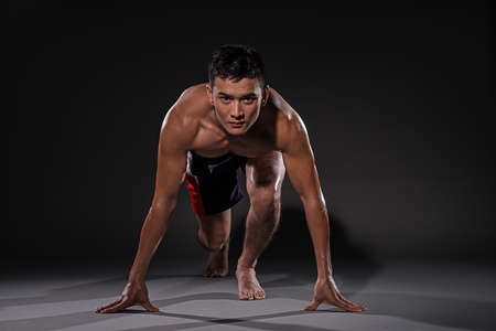 Isolated portrait of a young athlete ready to run の写真素材