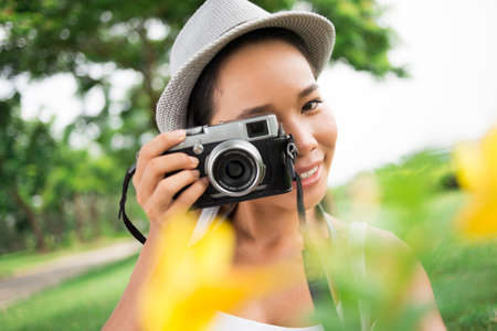 Close-up portrait of a lovely young photographer taking a picture of youの写真素材