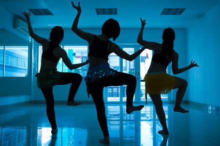 Silhouettes of women dancing Arabic dances in the studioの写真素材