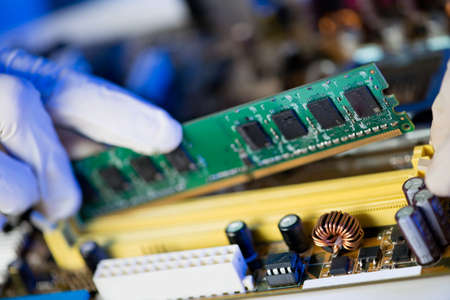 Cropped image of an electronic engineer putting RAM into the memory slot on motherboardの写真素材