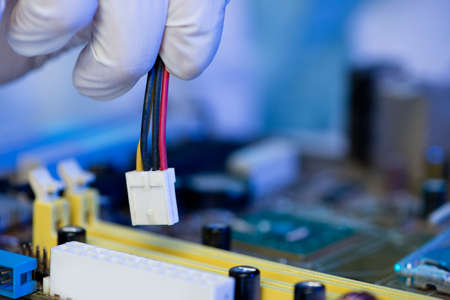 Copy-spaced image of a human hand installing a connector on the foregroundの写真素材