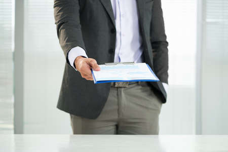 Cropped image of a businessman holding a clipboard with the company?s strategy on the foregroundの写真素材