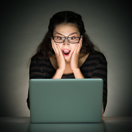 Image of a young girl shocked of information while networking over grey 