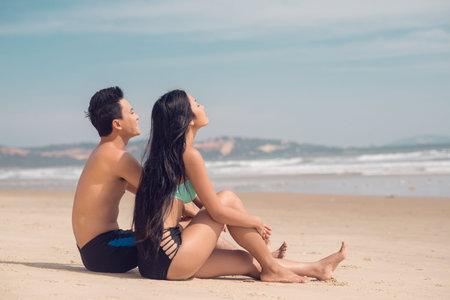 Copy-spaced image of a young couple sunbathing on a sandy beach の写真素材