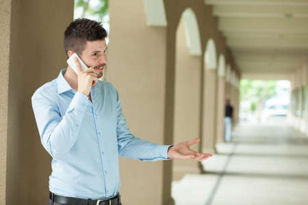 Copy-spaced image of a businessman having emotional telephone conversation on the foreground の写真素材