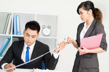 Businessman giving phone to the colleaguesの写真素材