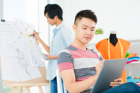 Young couple of designers in the process of clothes making の写真素材