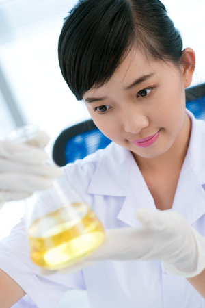 Young laboratory worker taking a close look at reagentの写真素材