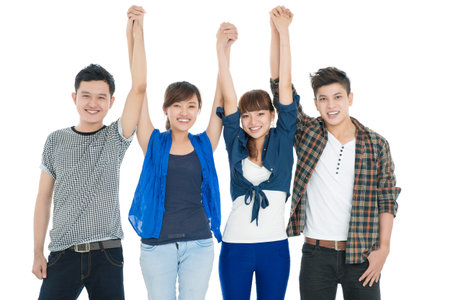 Portrait of a group of friends with raised handsの写真素材