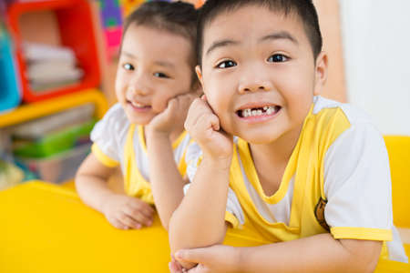 Boy and girl sitting behind the deskの写真素材