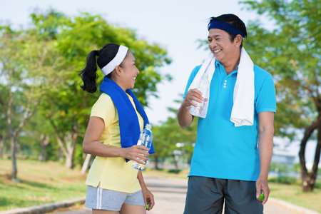 Couple of seniors standing in the park and laughingの写真素材