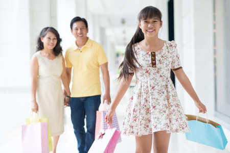Portrait of an excited teenager standing with shopping-bags on the foregroundの写真素材