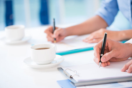 Close-up of hands writing something at the conferenceの写真素材