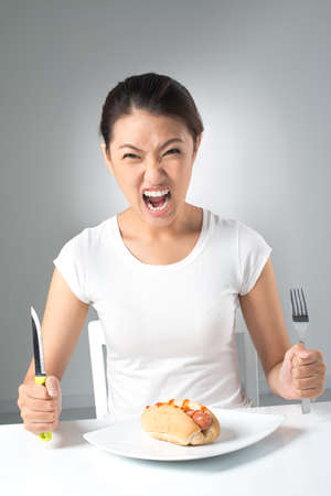 Vertical image of a crazy girl demanding more fast-foodの写真素材