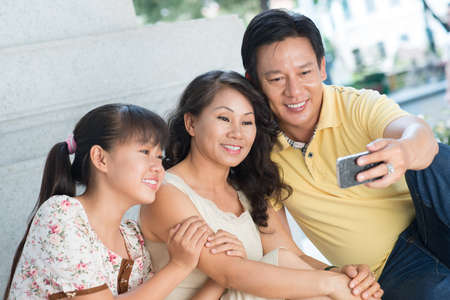 Close-up of a happy family making self-portrait by the smartphoneの写真素材