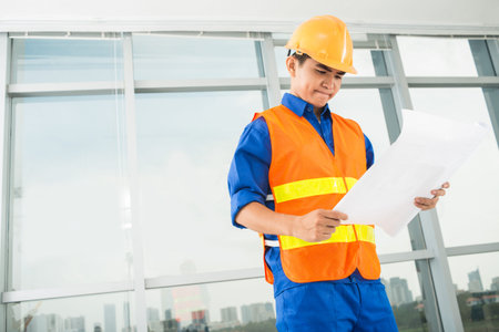 Copy-spaced image of a young architect concentrated on the blueprint