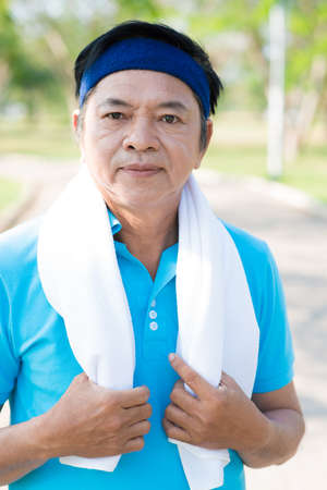 A senior man with a towel in the parkの写真素材