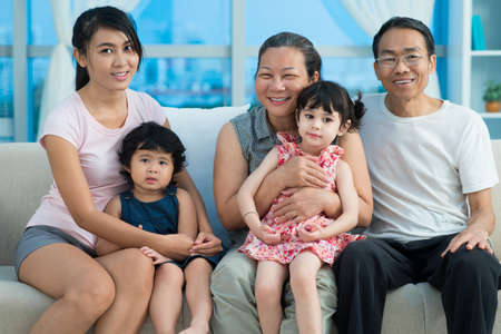 Close-up image of an mixed-race family smiling and looking at cameraの写真素材