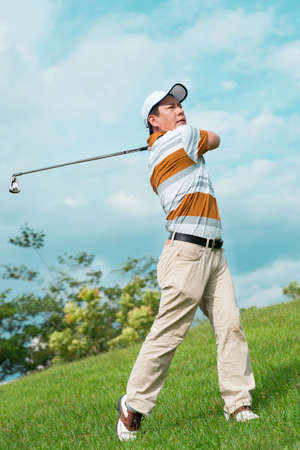 Full-length image of a man playing golf outside の写真素材