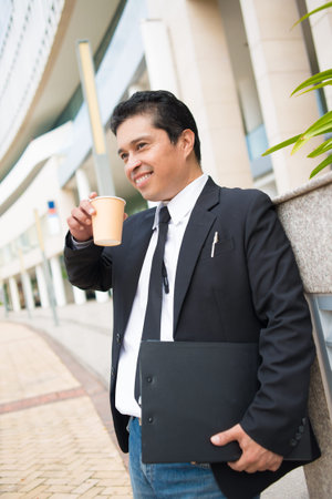 Vertical image of a smiling businessman during the coffee break