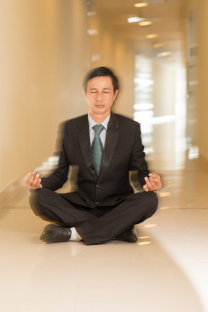 Vertical image of a relaxed businessman in the lotus positionの写真素材