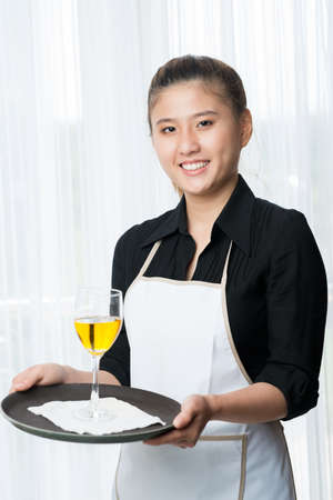 Young waitress with a tray in handsの写真素材