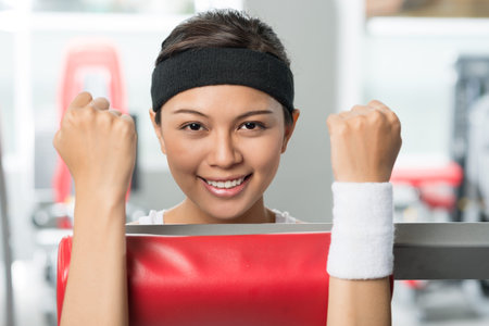 Close-up portrait of a strong young woman building muscles on a workout