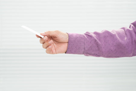 Close-up of a male hand giving business-cardの写真素材