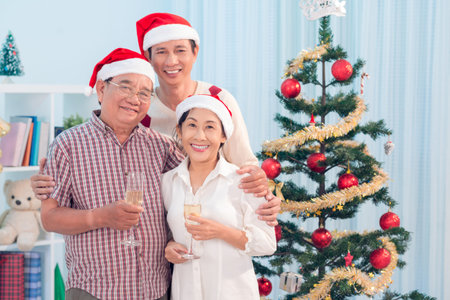 Portrait of a happy family standing by a decorated Christmas tree