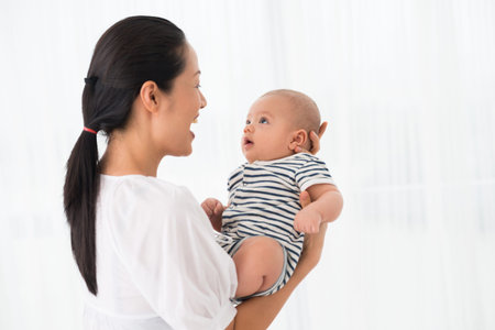 Copy-spaced image of an excited mother holding her son on hands over white