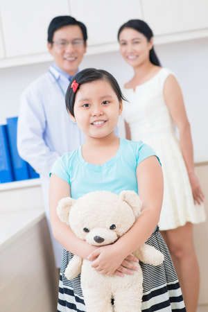 Vertical portrait of a little cute patient with teddy bear in hands standing on the foregroundの写真素材