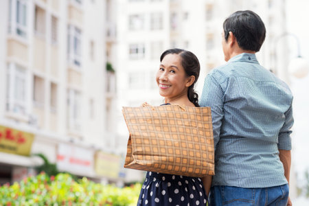 Copy-spaced portrait of a happy senior woman after shopping with her husband smiling and looking at camera on the foregroundの写真素材